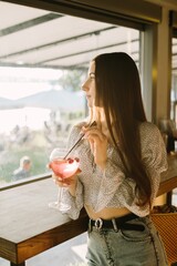 Young woman enjoying a refreshing drink at a cafe