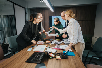 Corporate team engaged in a collaborative work session, reviewing documents during a meeting in a modern office environment.