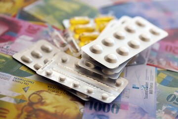 Swiss franc banknotes and medicine pills. The current francs money bills and drugs lies on table