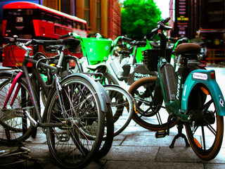 Obraz premium Boris Bikes lined up in London with a red double decker bus in the background