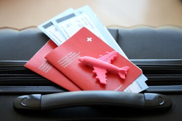 Swiss passport and avia tickets on travel bag. Pass and boarding tokens on bag close up