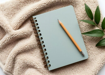 Minimalist Beige Spiral Notebook with Pencil on Light Cotton Fabric, Clean Elegant Pastel Workspace. Perfect for branding, social media, and design presentations. Modern composition with soft natural 