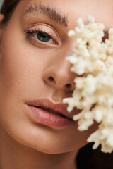 Captivating summer beauty of a young woman in studio with elegant floral accent