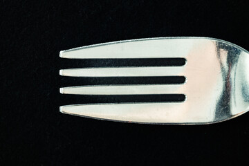 Close-up of a metal fork against a black background