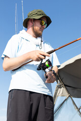 Obraz premium fisherman fishing, Fishing rod, spinning, fisherman against blue sky