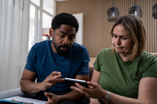 Stressed interracial couple worried about bills and rising costs, young man and woman facing inflation and housing crisis