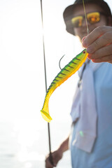 a man holds a rubber bait in his hand, fishing, spinning, preparation for fishing, wobblers,...