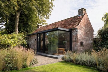 Fototapeta premium Charming countryside house blends traditional design with modern glass extension in a serene garden setting, surrounded by lush greenery and tall trees