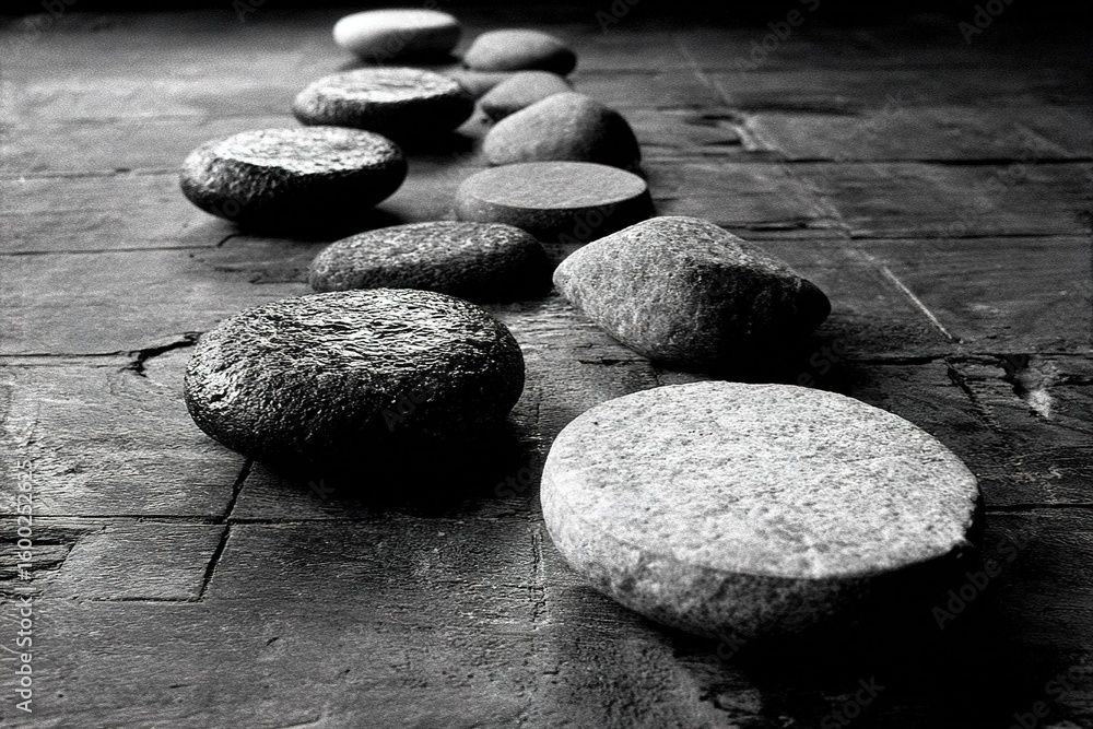 Poster pebbles arranged in a line on a textured surface create a calming aesthetic in a minimalist setting 