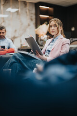 A focused woman participates in a work discussion, holding a tablet, portraying professionalism in...