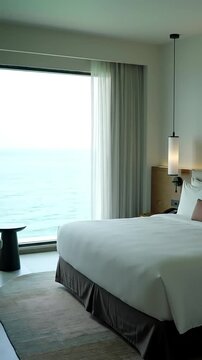 Serene Seaside Retreat: A spacious and elegant hotel room with an expansive window offers a breathtaking view of the ocean, capturing the tranquility and relaxation of coastal living.