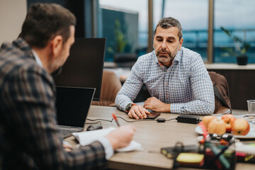 Two colleagues collaborate during an office meeting, emphasizing resolution and decision-making.