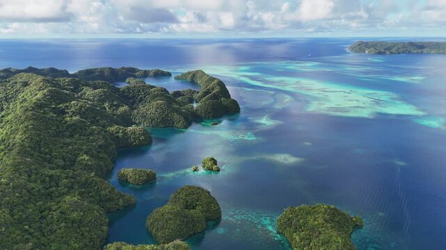 Sweeping drone shot revealing the crystal blue waters and islands in Palau. Wide revealing shot.