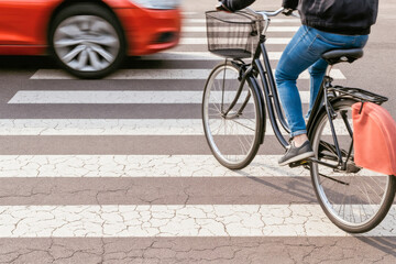 CYCLIST RIDING ACROSS URBAN CROSSWALK WHILE A CAR PASSES - Empha