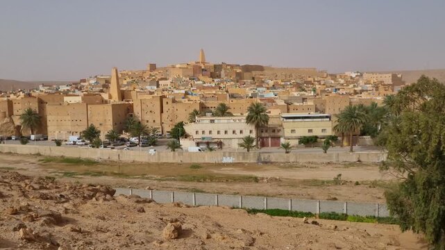 Wide shot of a hilltop district in the Saharan oasis town of Ghardaia, Algeria, revealing the traditional Mozabite houses nestled in the desert landscape