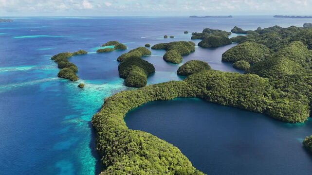 Stunning drone footage revealing the vivid aqua ocean and green-covered scattered islands of Palau.