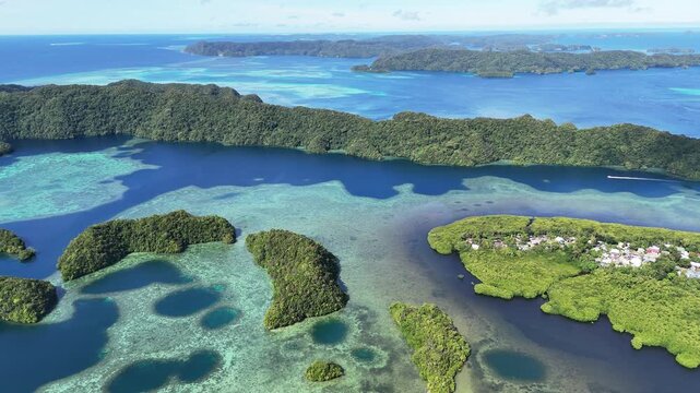 Scenic cinematic aerial drone shot showcasing the crystal blue waters and forests on the islands of Palau. Wide revealing drone shot.