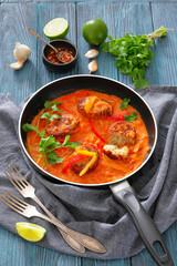 fish cakes in tomato vegetable coconut milk sauce