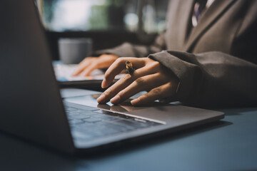Close up of business woman hands typing on laptop computer and digital tablet, searching and...