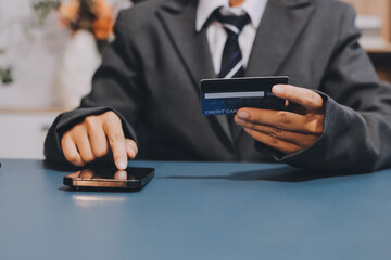 Online payment,businessman hands holding credit card and using  laptop for online shopping. Cyber...