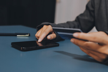 Online payment,businessman hands holding credit card and using  laptop for online shopping. Cyber...