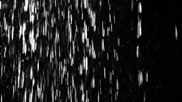 Rain falling on a black background for easy chroma or luma keying. Clean, isolated droplets, ideal for overlays, visual effects, and seamless compositing.
