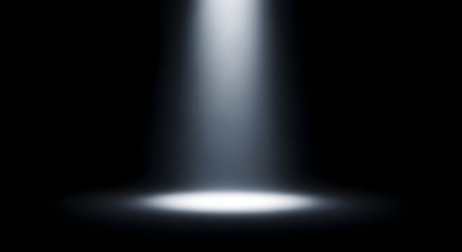 A dramatic spotlight shining down on a dark stage creating a focused bright circle of light below