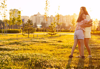 Mom hugs daughter at sunset