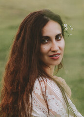 Beautiful summer portrait of a beauty in a white dress sitting in the grass and enjoying nature