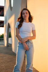 Young woman posing in urban setting during golden hour sunset