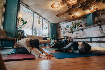 Participants engage in yoga poses on mats in a comfortable indoor space, featuring natural elements...