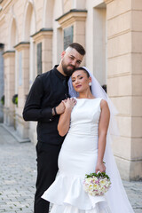 Romantic wedding portrait of a bride and groom hugging lovingly in front of a classic European...