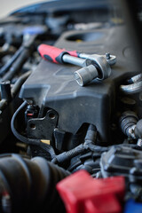Close-up of wrench socket tool lying on car engine during maintenance work. Vehicle repair concept