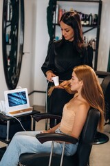 Examining the health of hair. Woman is in a beauty salon with hair stylist