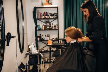 Woman is in a beauty salon with hair stylist