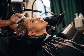 Healthy massage for the head and skin. Woman is in a beauty salon with hair stylist