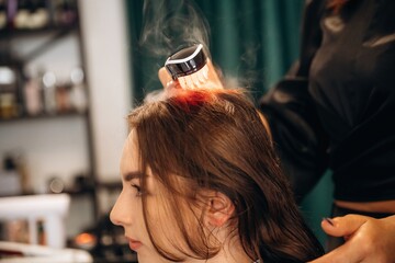 Woman is in a beauty salon with hair stylist