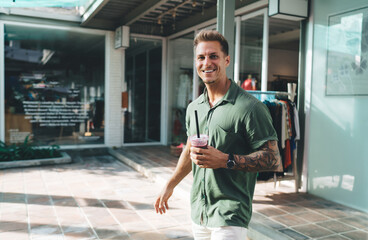 Confident man smiling with smartwatch and drink in hand, representing digital ease, wearable...