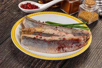 Salted marinated herring fillet with spices