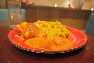 Delicious Indian Cuisine Plate with Spicy Egg Curry, Fried Snacks, and Aromatic Yellow Rice in a Warm Restaurant Setting – Traditional South Asian Food Close-Up for Menu, Blog, or Culinary Use