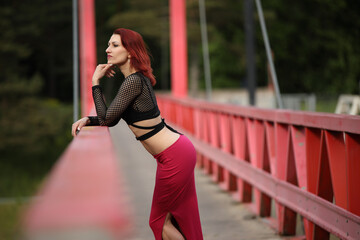 Stylish woman posing on a vibrant red bridg
