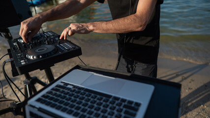 Close up of DJ's hands while working outdoors. 