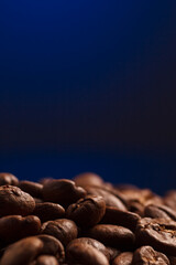 coffee beans on a dark background with a blue highlight on the background