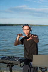 Caucasian man works as a DJ on the beach. 