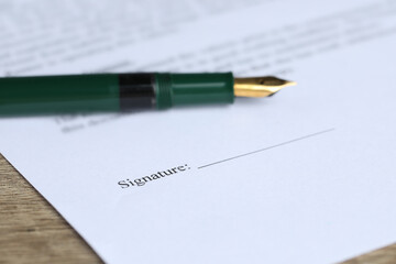 Notary document and fountain pen on wooden table, selective focus