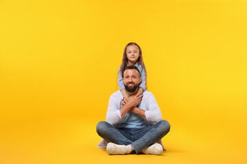 Family. Happy father and his daughter on yellow background