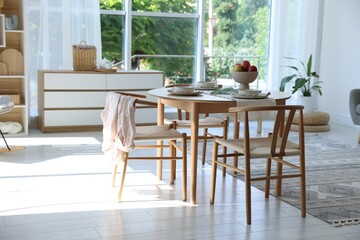 Stylish table setting, chairs and decor in dining room. Interior design