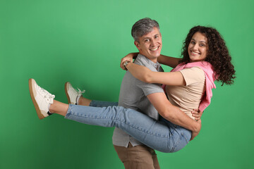 Happy friends hugging each other on green background