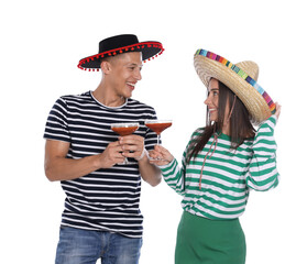 Happy couple in sombrero and Flamenco hats with cocktails on white background