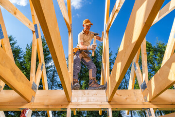Skilled Worker Constructs Wooden Framework Under Blue Sky at Outdoor Construction Site
